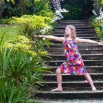 This is an image of a beautiful young girl doing a warrior two yoga pose in Fiji.